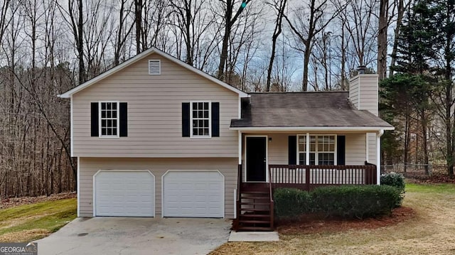 split level home with covered porch, a chimney, and an attached garage