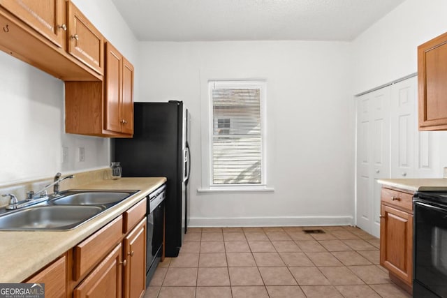 kitchen with black range with electric stovetop, light countertops, a sink, and dishwashing machine