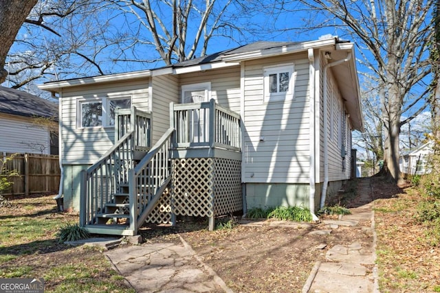 view of front of property with stairway, fence, and a wooden deck