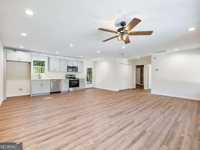 8079 Beachwood Dr, Murrayville, GA 30564 - unfurnished living room with recessed lighting, a sink, visible vents, baseboards, and light wood finished floors