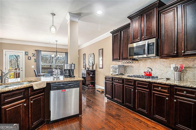 kitchen with stainless steel appliances, dark wood-type flooring, a sink, and backsplash