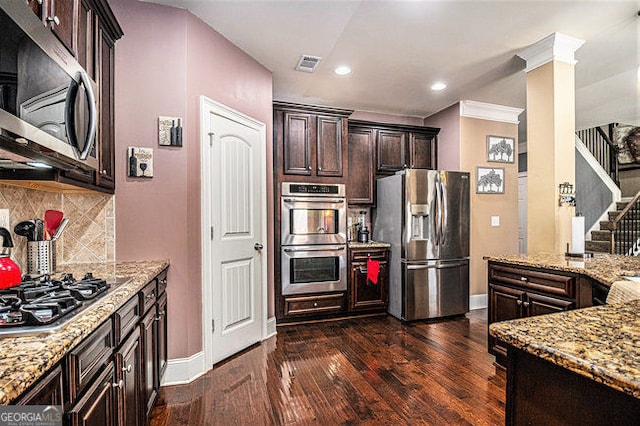 kitchen with stainless steel appliances, visible vents, decorative backsplash, dark wood-type flooring, and light stone countertops