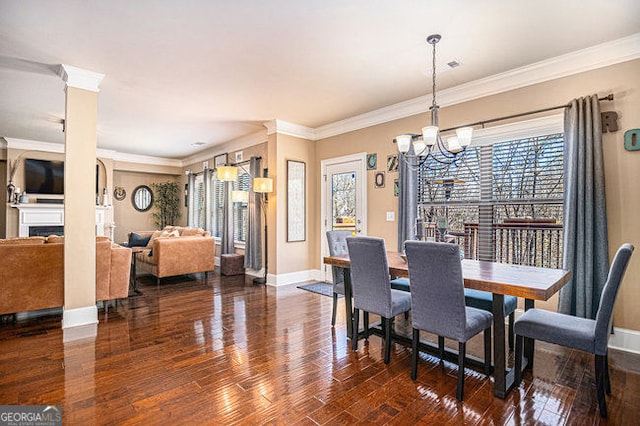 dining space featuring a fireplace, wood finished floors, and a healthy amount of sunlight