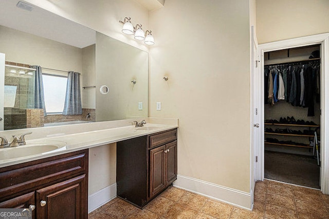 full bathroom featuring double vanity, a sink, and baseboards