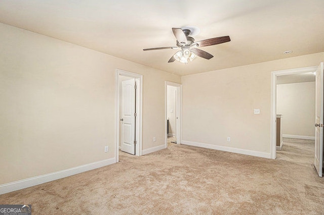 unfurnished bedroom featuring baseboards, a ceiling fan, and light colored carpet