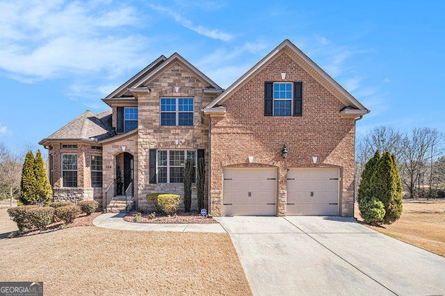 traditional-style home with a garage, stone siding, concrete driveway, and brick siding