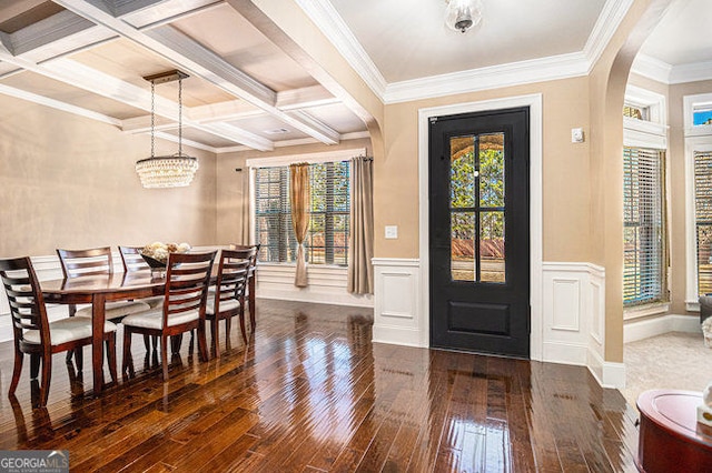 entrance foyer with arched walkways, wood-type flooring, wainscoting, coffered ceiling, and beamed ceiling