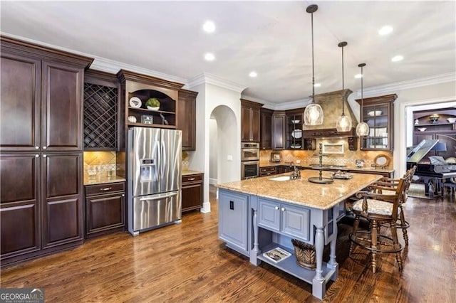 kitchen featuring arched walkways, a sink, appliances with stainless steel finishes, open shelves, and glass insert cabinets