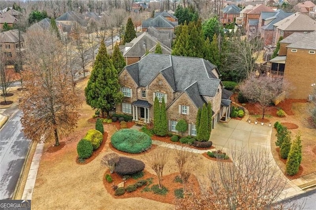 view of front of property featuring stone siding, driveway, and a residential view