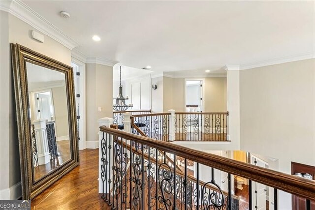 hallway featuring baseboards, dark wood-style floors, crown molding, an upstairs landing, and recessed lighting