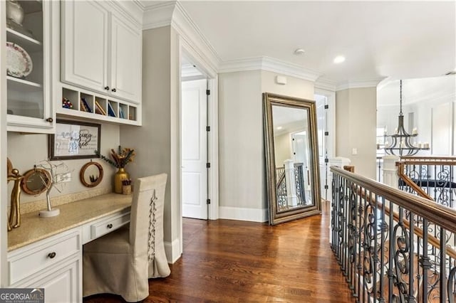 office space with dark wood-style flooring, baseboards, ornamental molding, built in study area, and an inviting chandelier