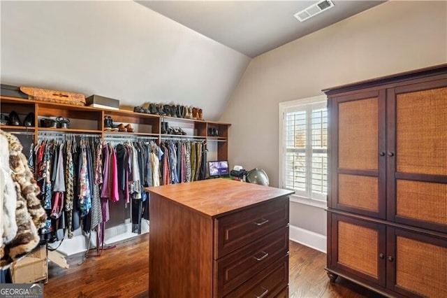 walk in closet with vaulted ceiling, dark wood-style floors, and visible vents