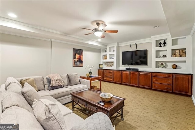 living area featuring ornamental molding, built in shelves, and a ceiling fan