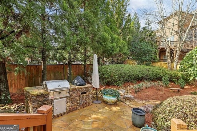 view of patio with a grill, fence, and area for grilling