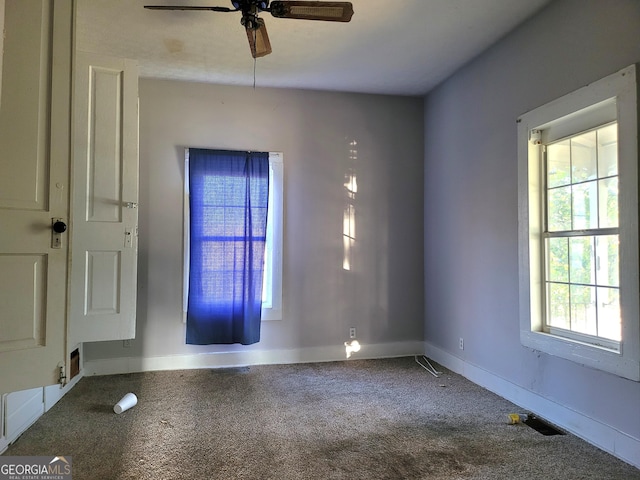 carpeted empty room featuring baseboards, ceiling fan, and visible vents