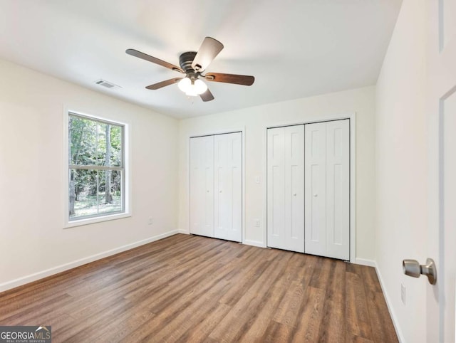 8087 Beachwood Dr, Murrayville, GA 30564 - unfurnished bedroom with visible vents, baseboards, two closets, and wood finished floors