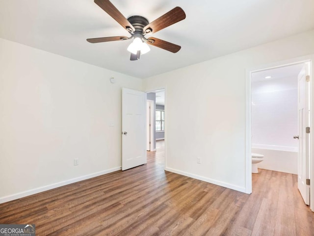 8087 Beachwood Dr, Murrayville, GA 30564 - unfurnished bedroom featuring ensuite bathroom, baseboards, and wood finished floors