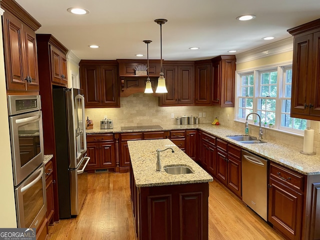 kitchen with light wood-style floors, appliances with stainless steel finishes, and a sink