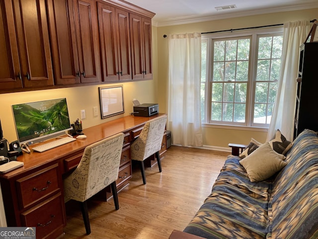 office area with light wood-style flooring, visible vents, ornamental molding, and baseboards