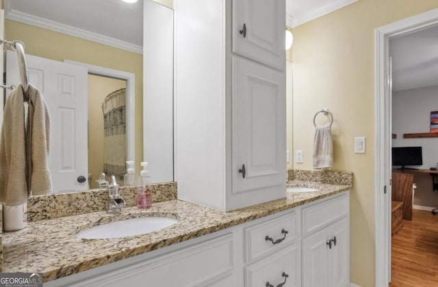 bathroom featuring curtained shower, wood finished floors, a sink, ornamental molding, and double vanity