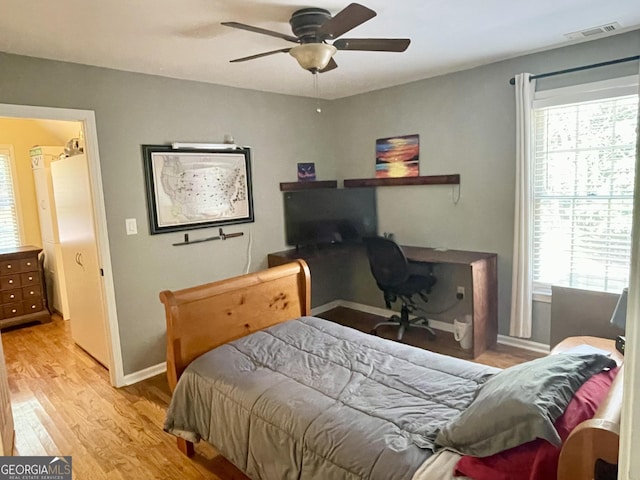 bedroom with multiple windows, light wood-type flooring, visible vents, and baseboards