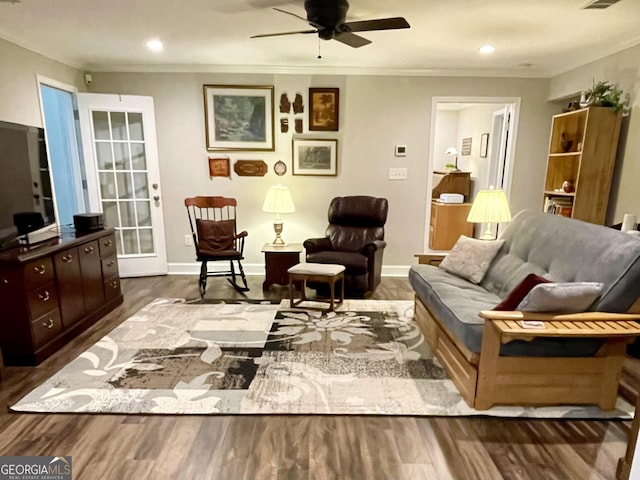 living area featuring ornamental molding, wood finished floors, and baseboards