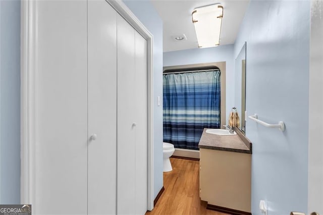 full bath featuring wood finished floors, a shower with shower curtain, vanity, and toilet