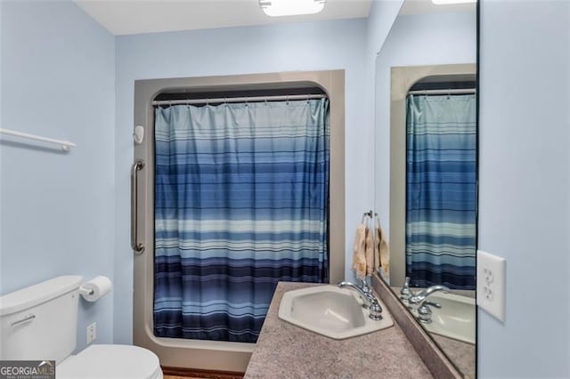 bathroom with vanity, shower / bath combination with curtain, and toilet