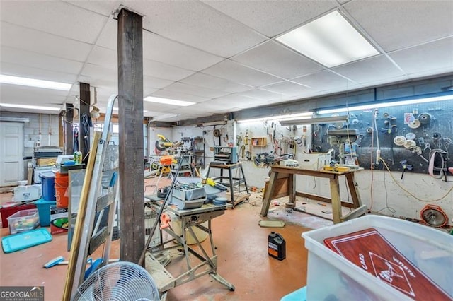 workout area featuring a drop ceiling and a workshop area