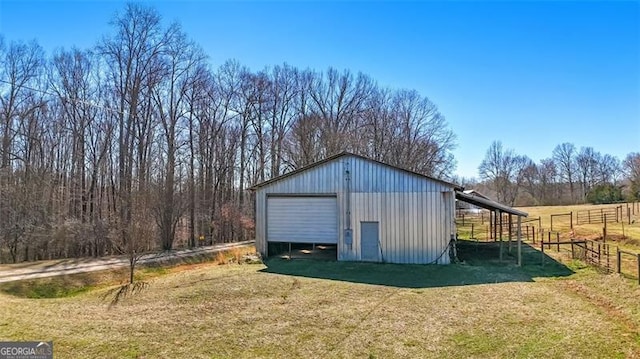 view of pole building featuring fence and a lawn