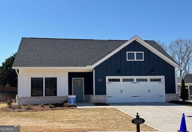 modern inspired farmhouse featuring board and batten siding, driveway, and a garage