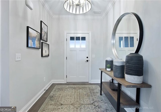 foyer entrance featuring a chandelier, dark wood-style flooring, crown molding, and baseboards