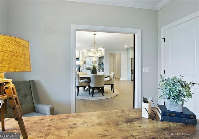 dining area featuring crown molding, a chandelier, and wood finished floors