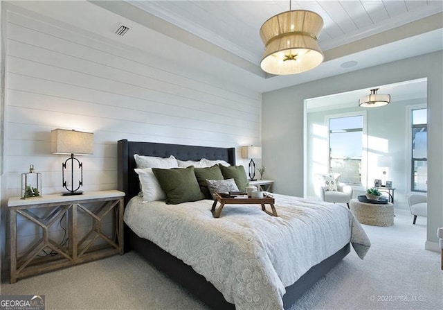 bedroom featuring ornamental molding, a tray ceiling, carpet, and visible vents