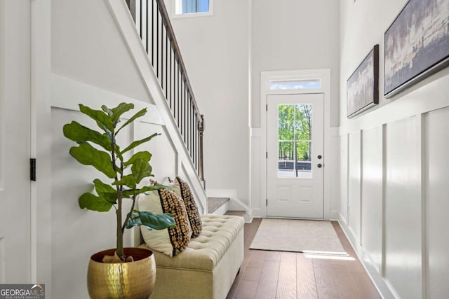 interior space with a towering ceiling, stairs, and wood finished floors