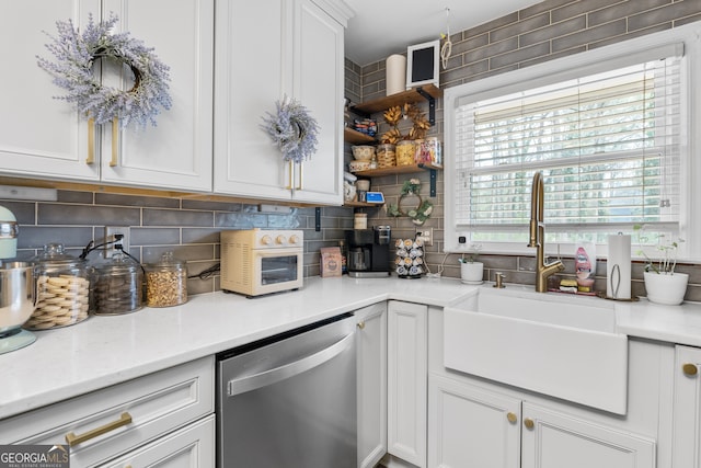 kitchen with a sink, backsplash, dishwasher, and light countertops