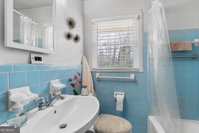 full bath featuring a wainscoted wall, shower / tub combo, a sink, and tile walls