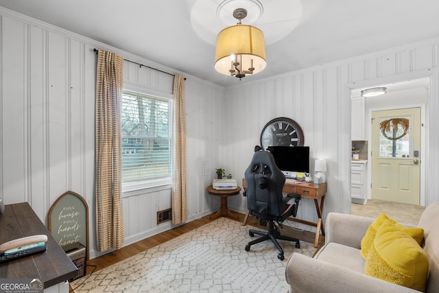 office area featuring light wood-type flooring, a wealth of natural light, and crown molding