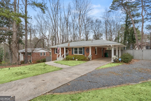 ranch-style house with brick siding, fence, driveway, a carport, and a front yard