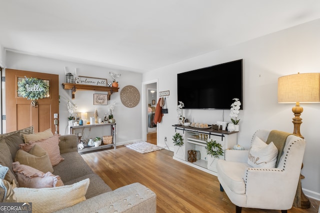 living area with baseboards and wood finished floors