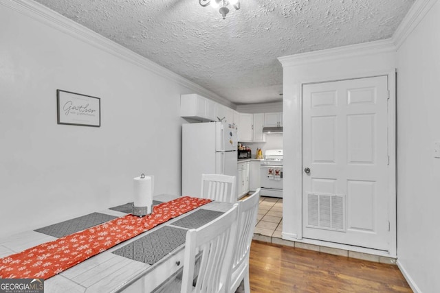 dining room featuring visible vents, crown molding, a textured ceiling, and wood finished floors