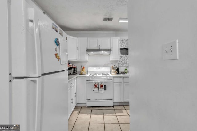 kitchen featuring light tile patterned floors, visible vents, white cabinetry, white appliances, and under cabinet range hood