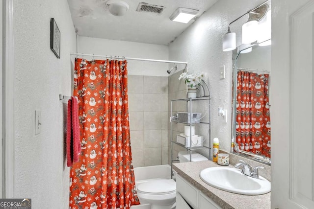 full bath featuring toilet, a textured wall, vanity, and visible vents