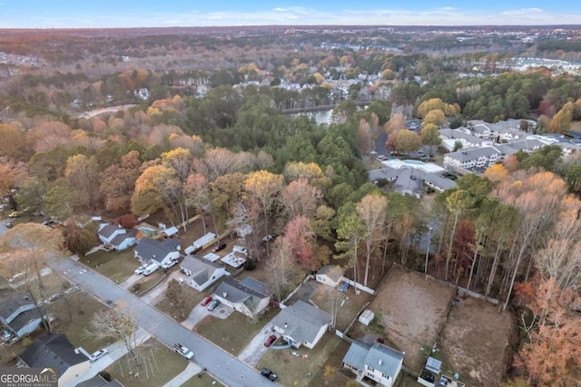 drone / aerial view featuring a residential view and a wooded view