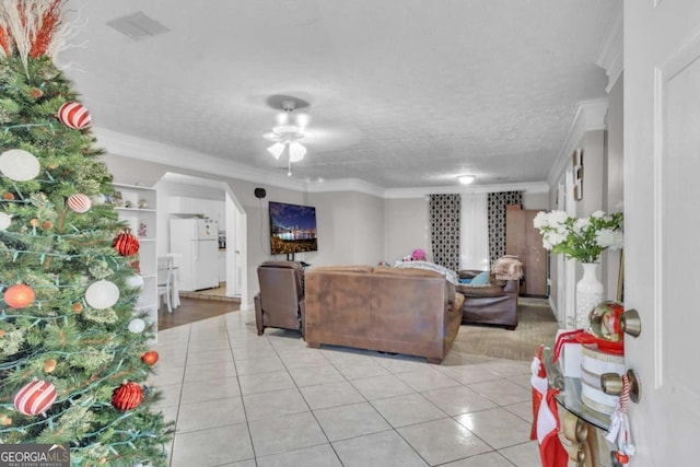 living room featuring ceiling fan, crown molding, a textured ceiling, and light tile patterned floors