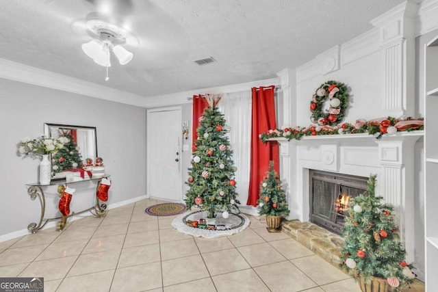 living area featuring light tile patterned floors, a warm lit fireplace, a textured ceiling, and visible vents