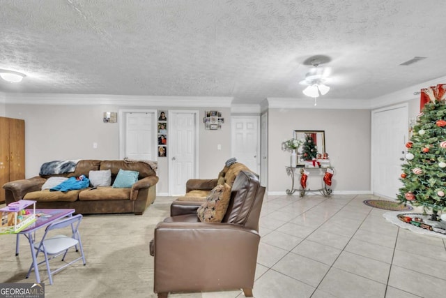 living room with light tile patterned floors, a textured ceiling, visible vents, and crown molding