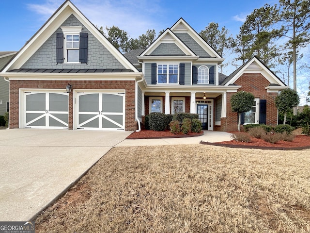 craftsman inspired home featuring a garage, concrete driveway, brick siding, and a front lawn