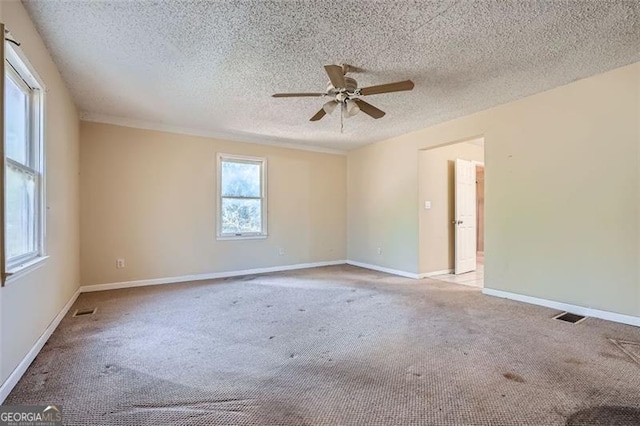 unfurnished room with carpet, visible vents, a ceiling fan, a textured ceiling, and baseboards