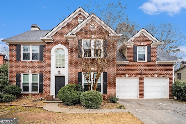 view of front of home featuring a garage, driveway, brick siding, and a chimney